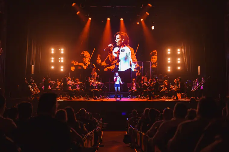 Una de las voces en el centro del escenario con la orquesta