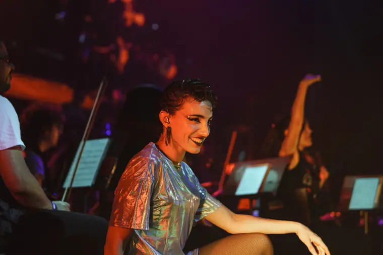 Voz sonriendo junto a la orquesta